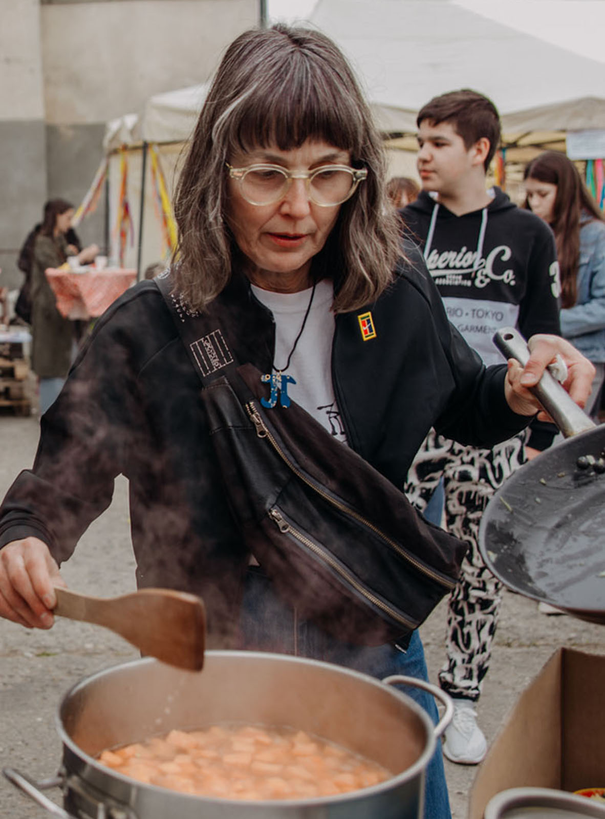 A volunteer stirs a large pot that contains food to distribute to those in need in Ukraine.