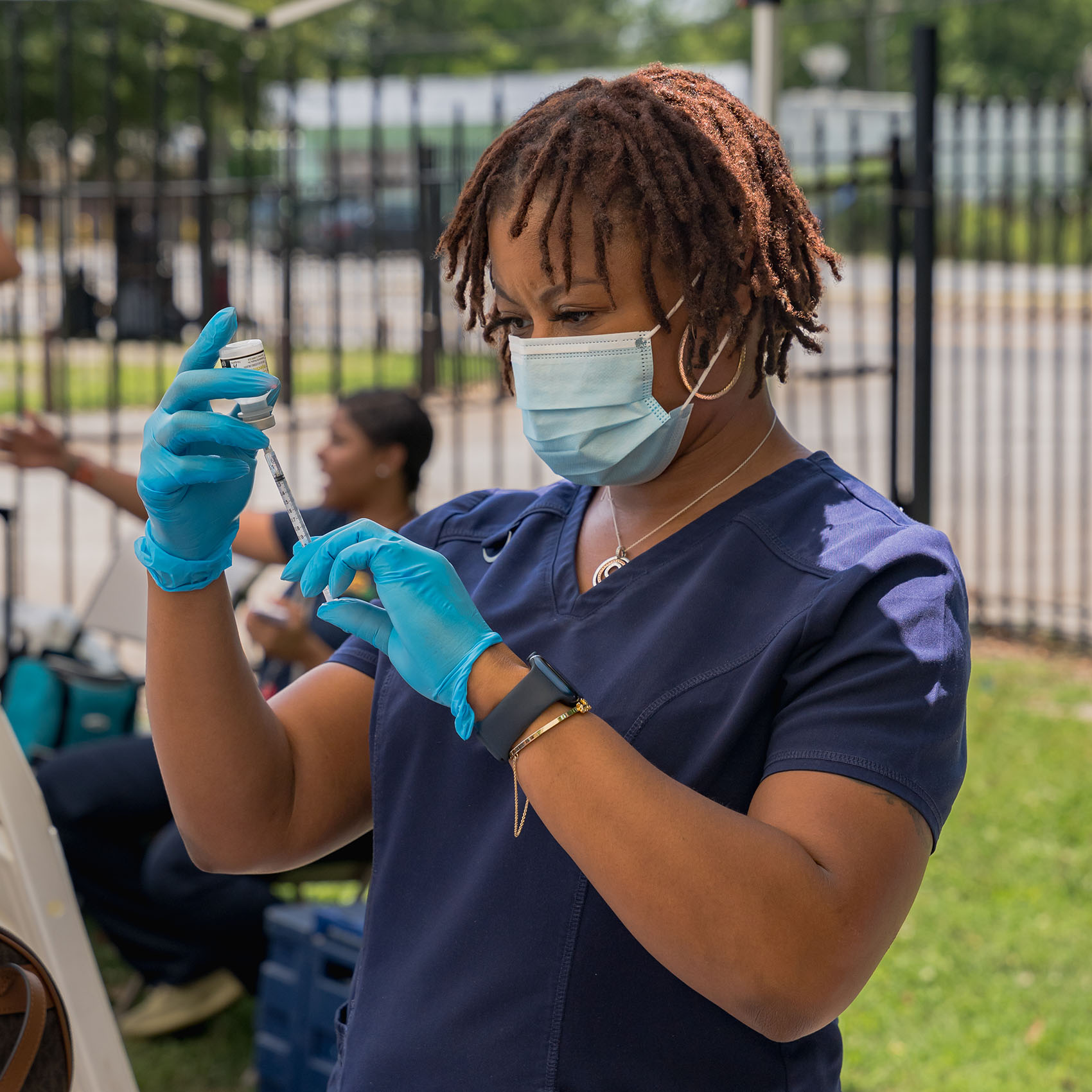 CORE staff administering a COVID vaccine at a community event.