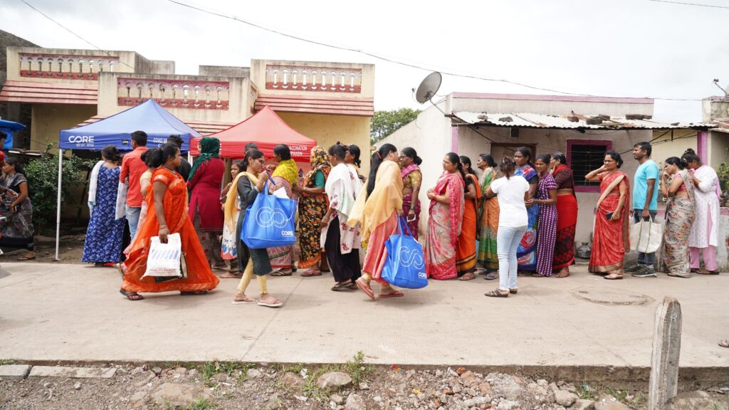 Recipients pass the line of those waiting during CORE's distribution of 400 food kits to vulnerable communities living in the outskirts of Pune on August 25, 2023. CORE Photo by Harshvardhan Magdum