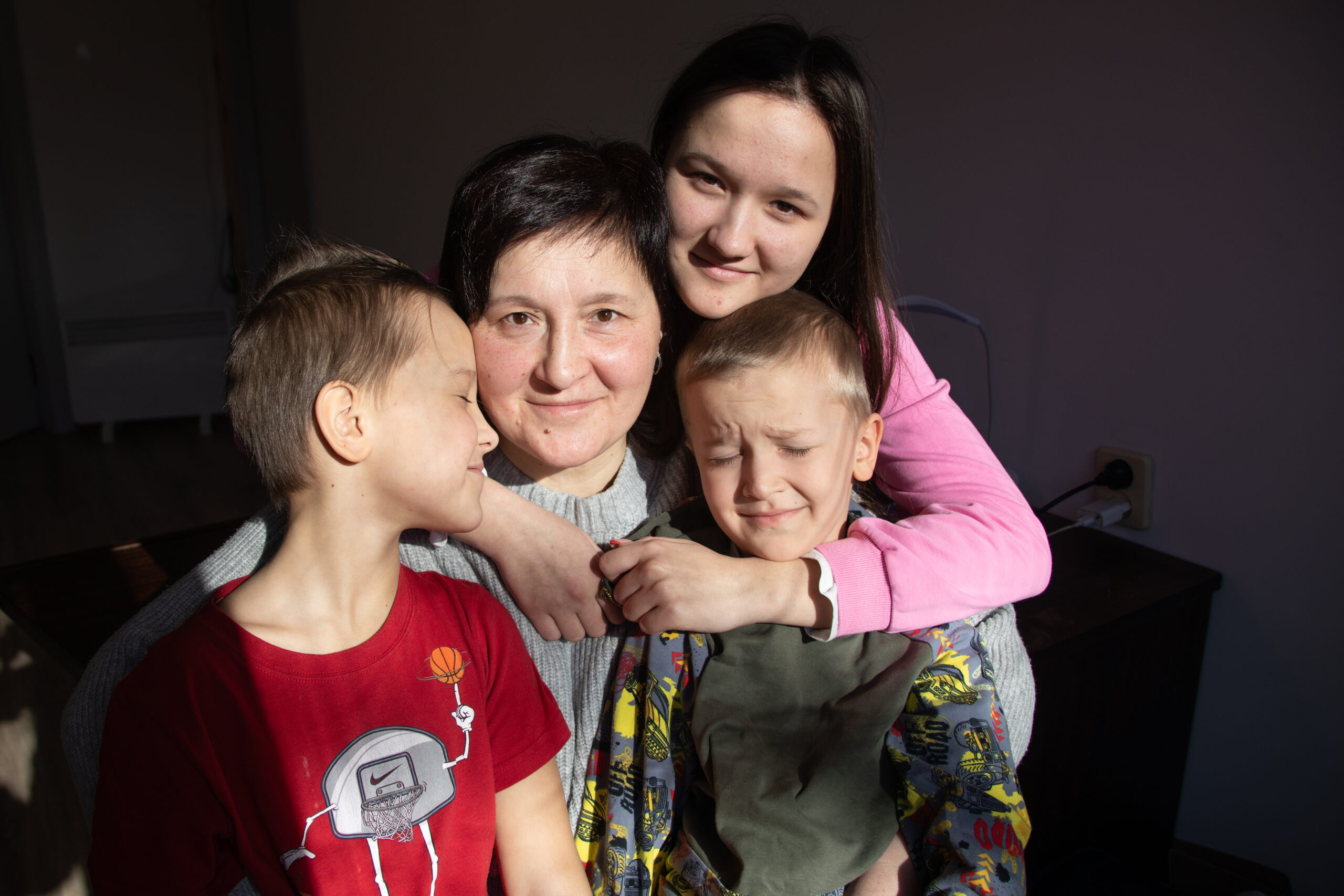 Ukrainian family poses for a photo inside their apartment funding through the Ukraine Humanitarian Fund