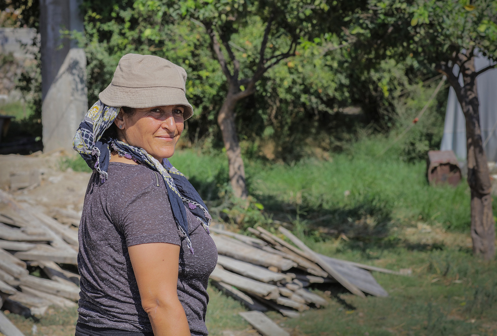 Photo of a greenhouse owner, Reyhani, standing outside of her business in the months after the 2023 earthquake in Turkey.