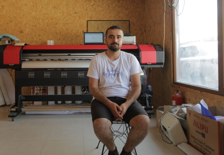 Osman sits in his advertising shop in the Hassa district of Hatay in Turkey after the devastating earthquake on February 6, 2023.
