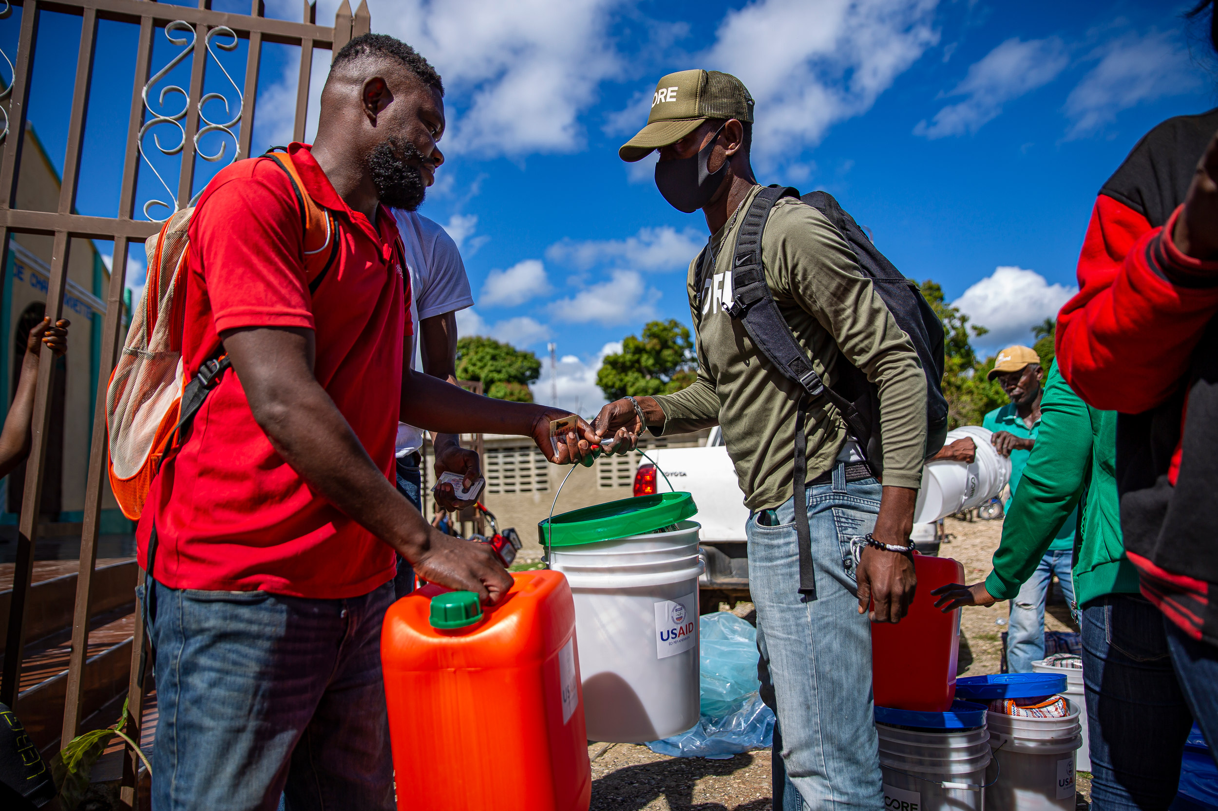 A member of CORE staff, distributes food kits to a Haitian local.