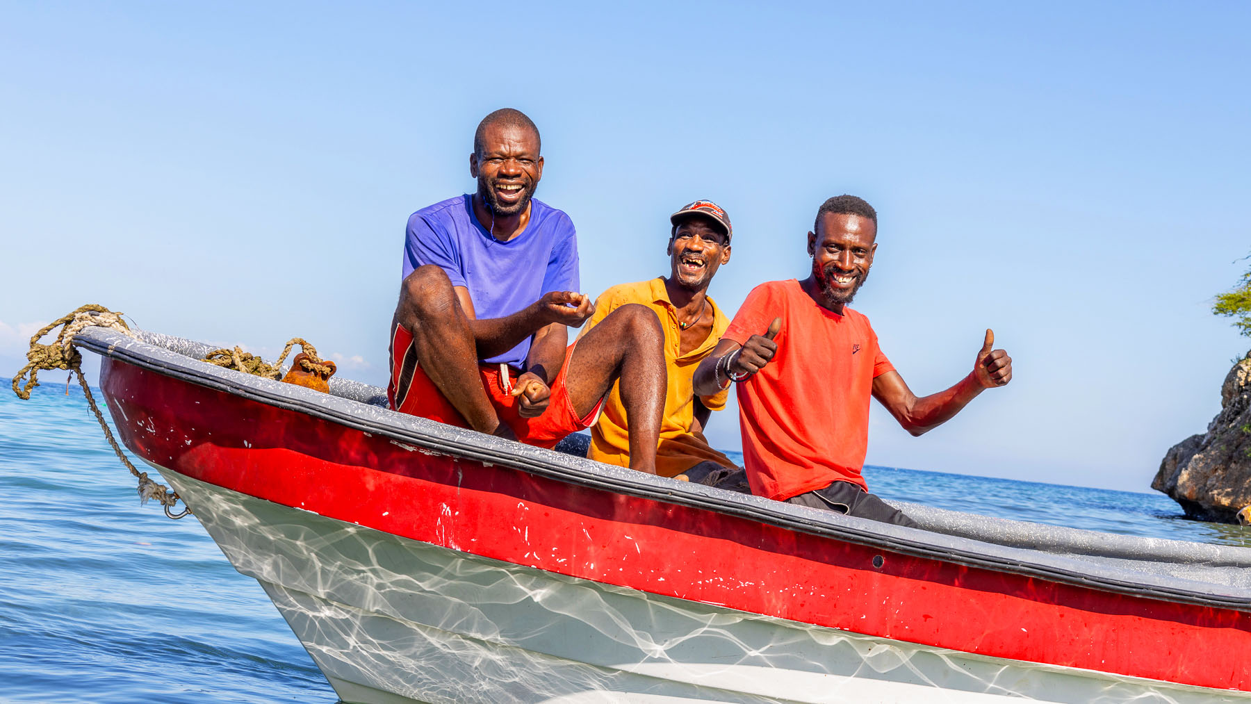 Fishermen sitting in a boat in southern Haiti pose for a photo.