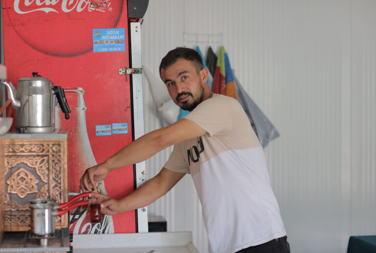 Haydar fills up a hot cup of tea inside his shop in the Hassa district of Hatay in Turkey after the devastating earthquake on February 6, 2023.