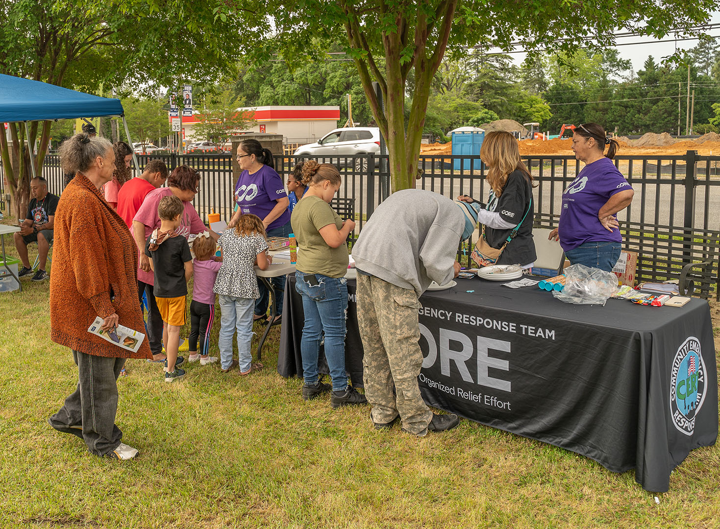 CORE NC Staff tabling at a community event and speaking with community members.