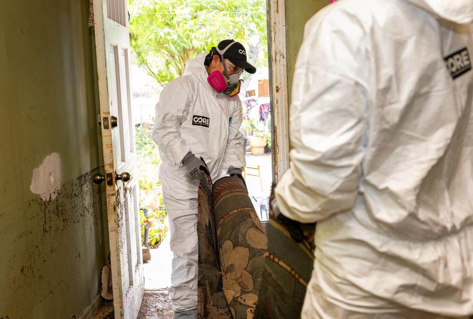 The high-water mark in the home is visible on the wall as sodden carpet is removed from Maria’s home.