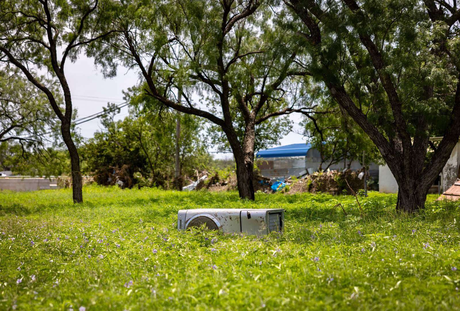 A washing machine lays where the flood waters deposited it near Maria’s home.