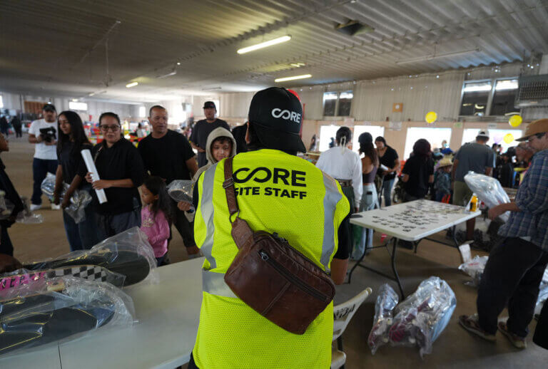 A CORE voluneteer passing out skateboards at a distribution event in Window Rock.