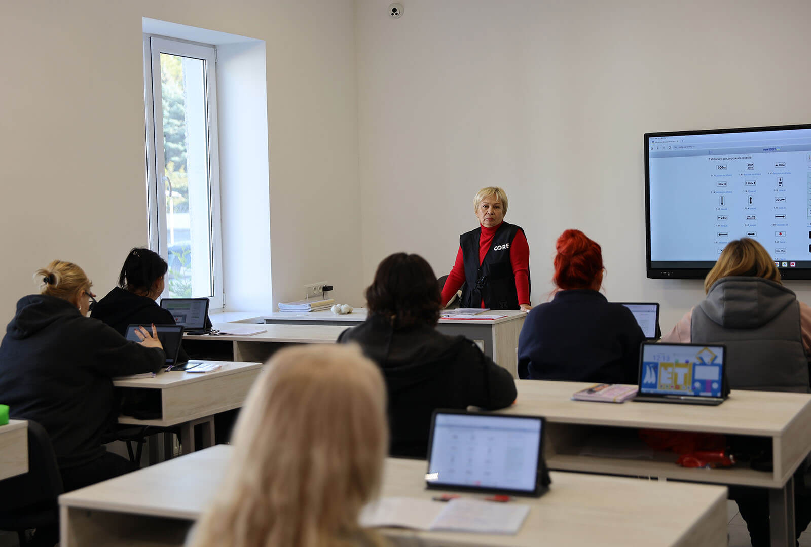 A teacher stands in the front of a classroom for tram driver training in Ukraine.