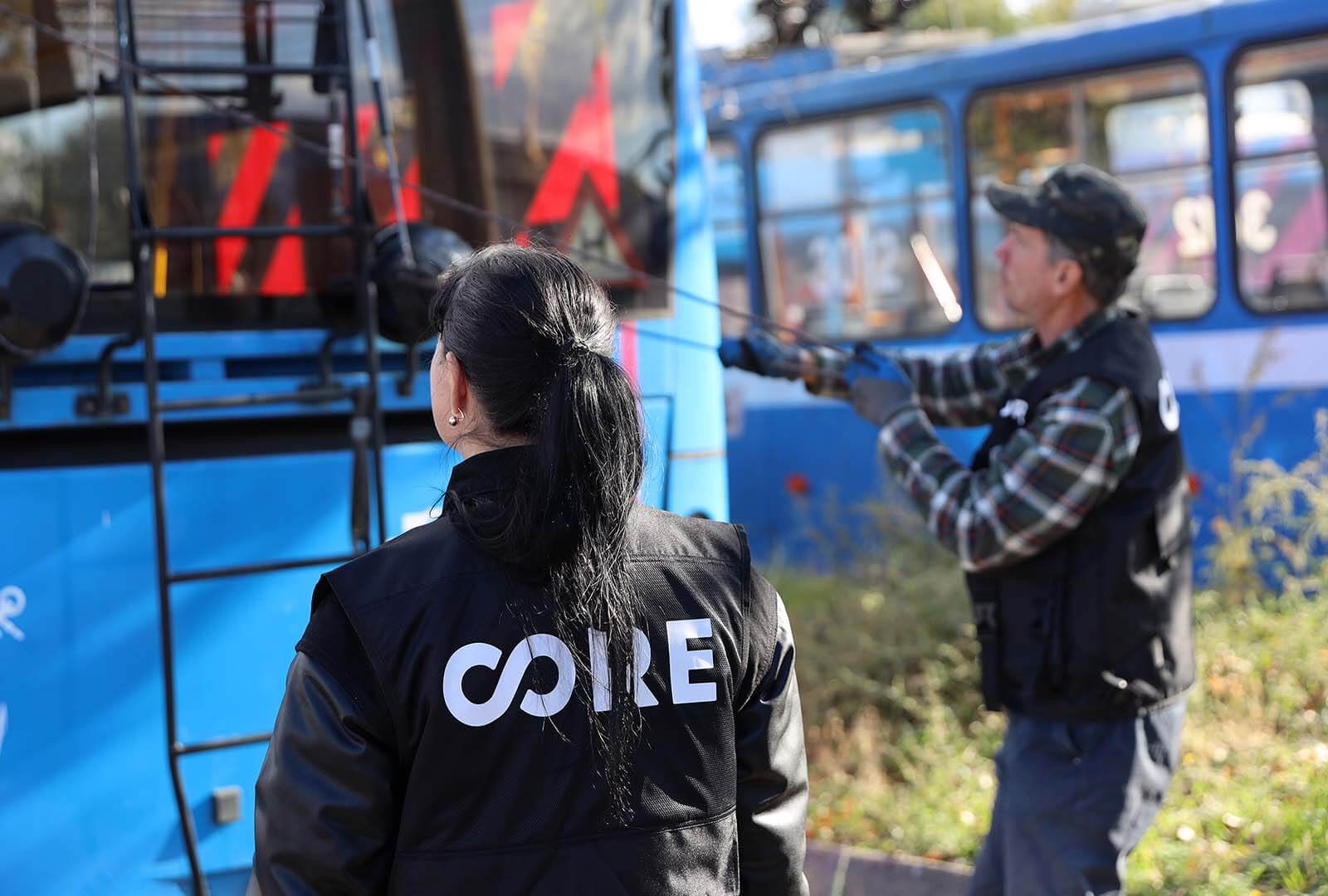 A tram driving student looks on at instructor showing her a tram.