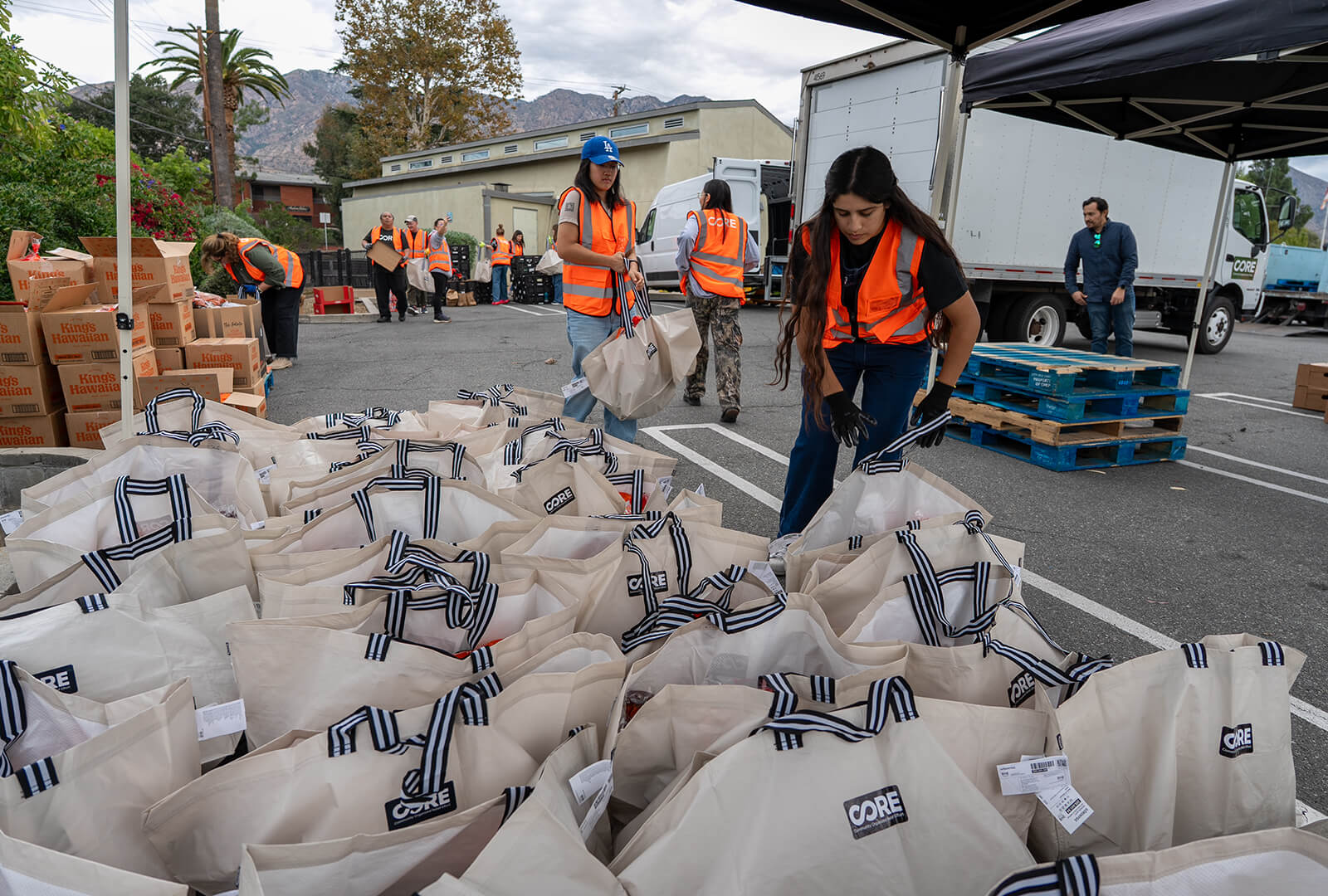 CORE staff adding Thanksgiving food to bag to be distributed to local families.