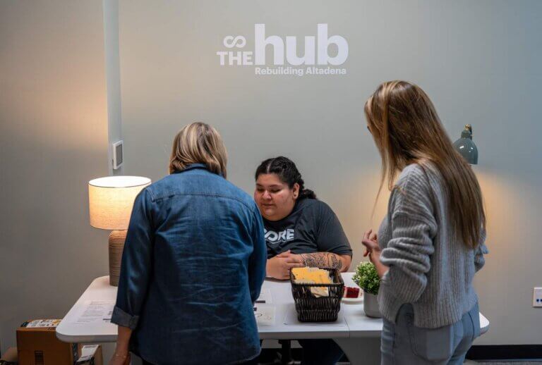 Two guests check in at The Hub's front desk.