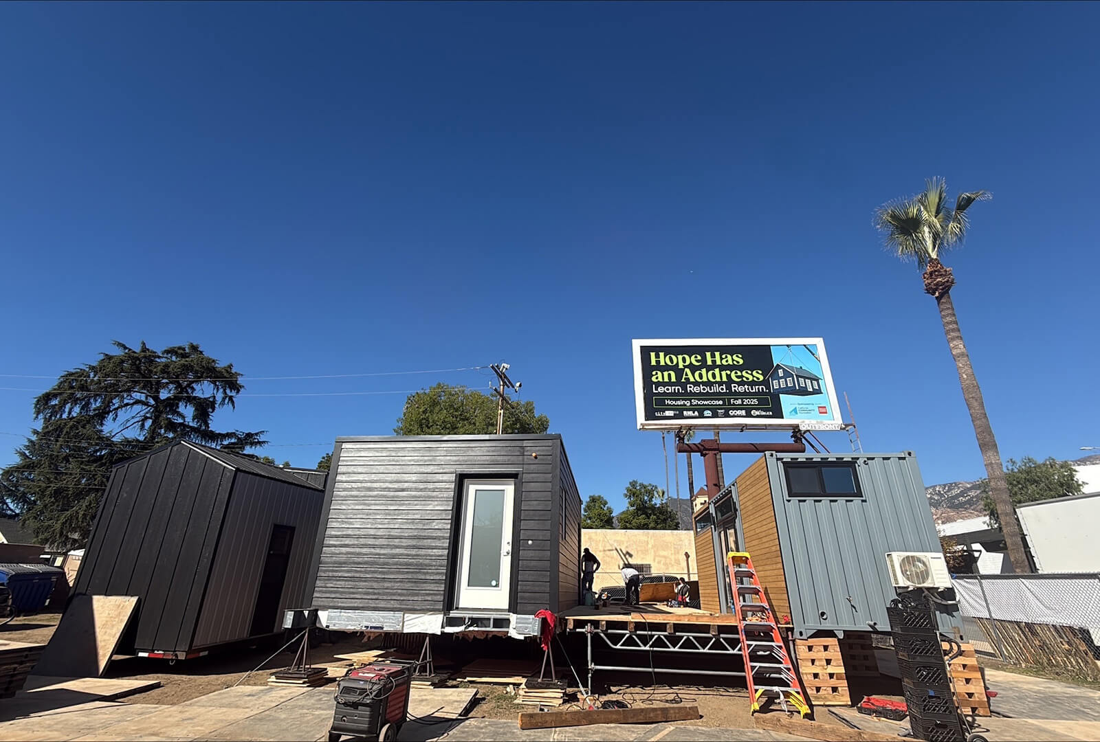 A veview of the prefab showcase in Altadena. It shows to prefab buildings next to each other connected by a wooden deck.