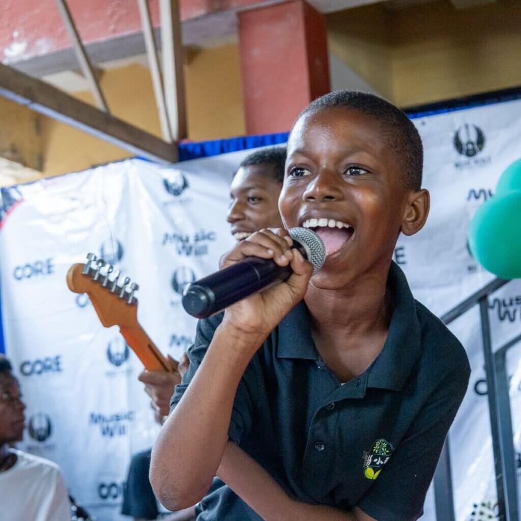young boy in haiti sings at a concert