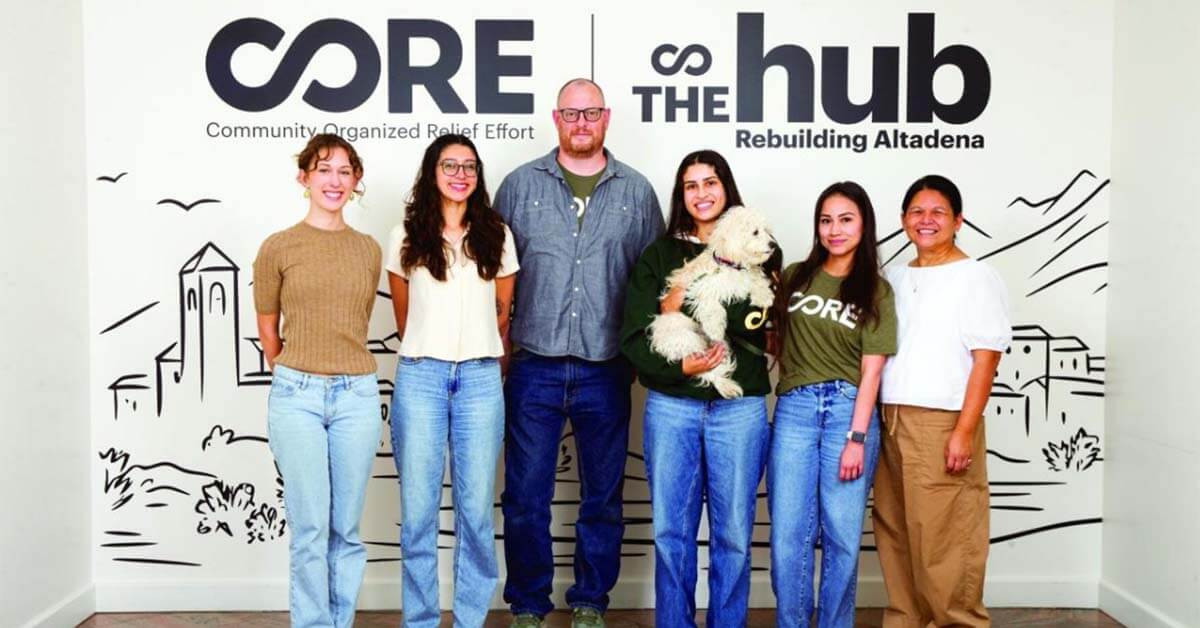 A group of CORE employees stand in front a mural wall at the Hub, their office space, in Altadena.