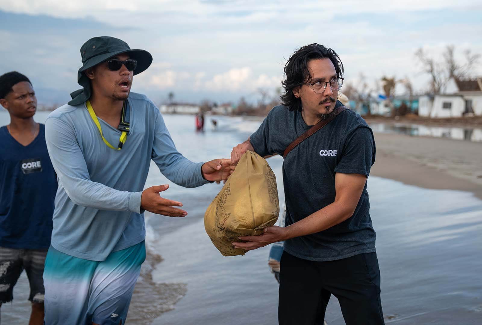 Staff standing in water, bringing supplies ashore in Jamaica.