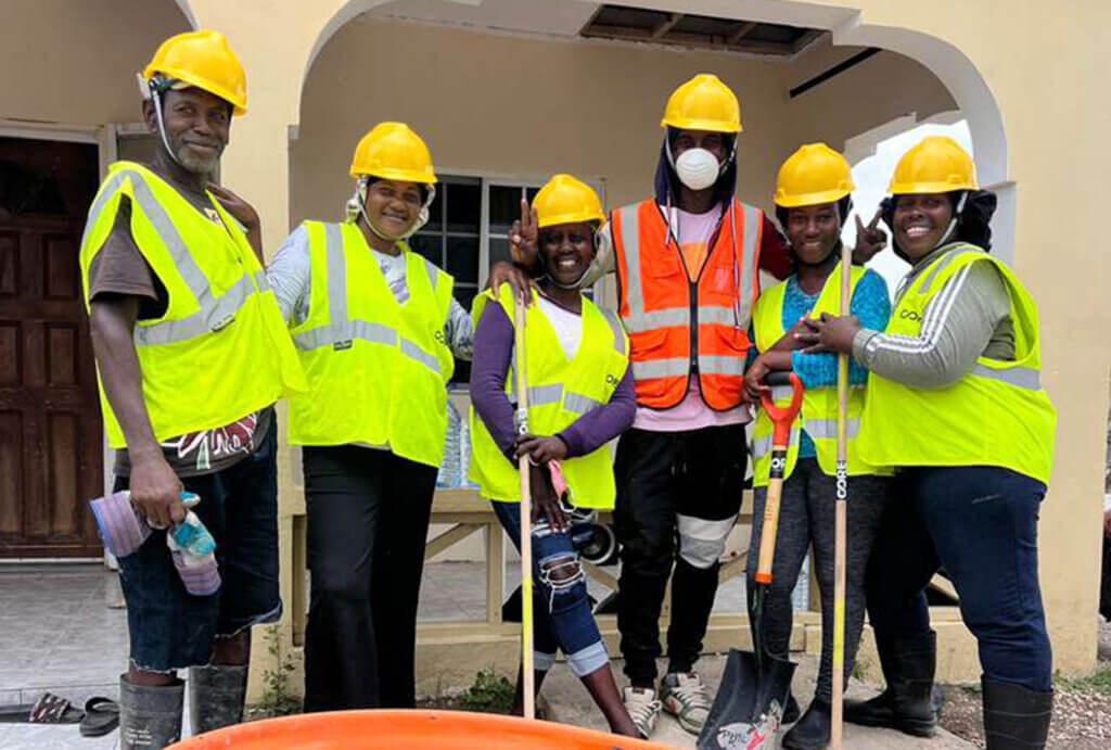 A group of people doing clean up work in Jamaica pose for a photo.