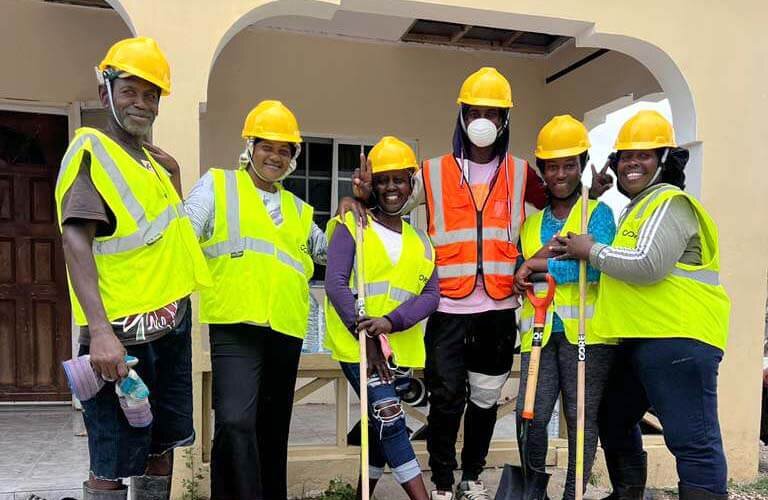 A group of people doing clean up work in Jamaica pose for a photo.