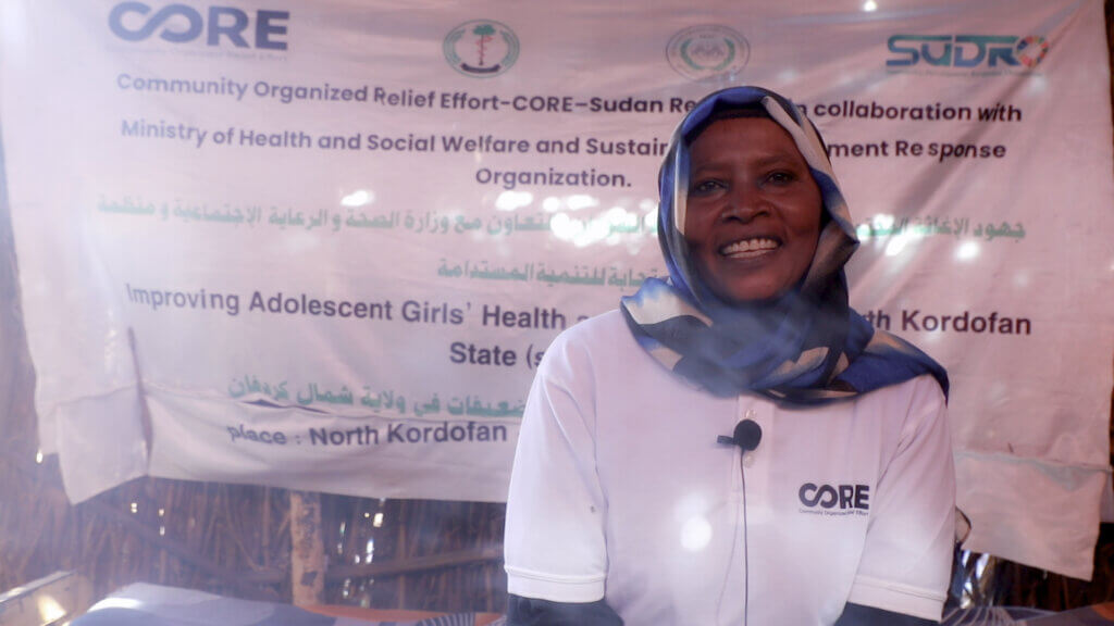 Al-Risala, a small business owner, sits at her shop stall in Sudan to be interviewed.