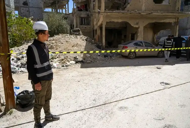 A member of CORE's team stands on one side of caution tape, keeping any neihgbors from getting to close to the unexploded ordnance work.