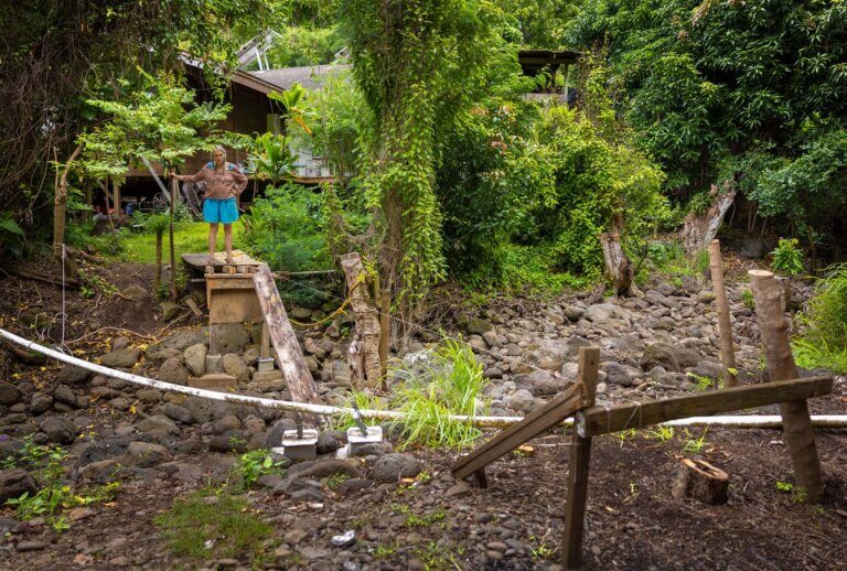 A woman stands at the end of foor bridge that had been destroyed by flooding in Hawaii.