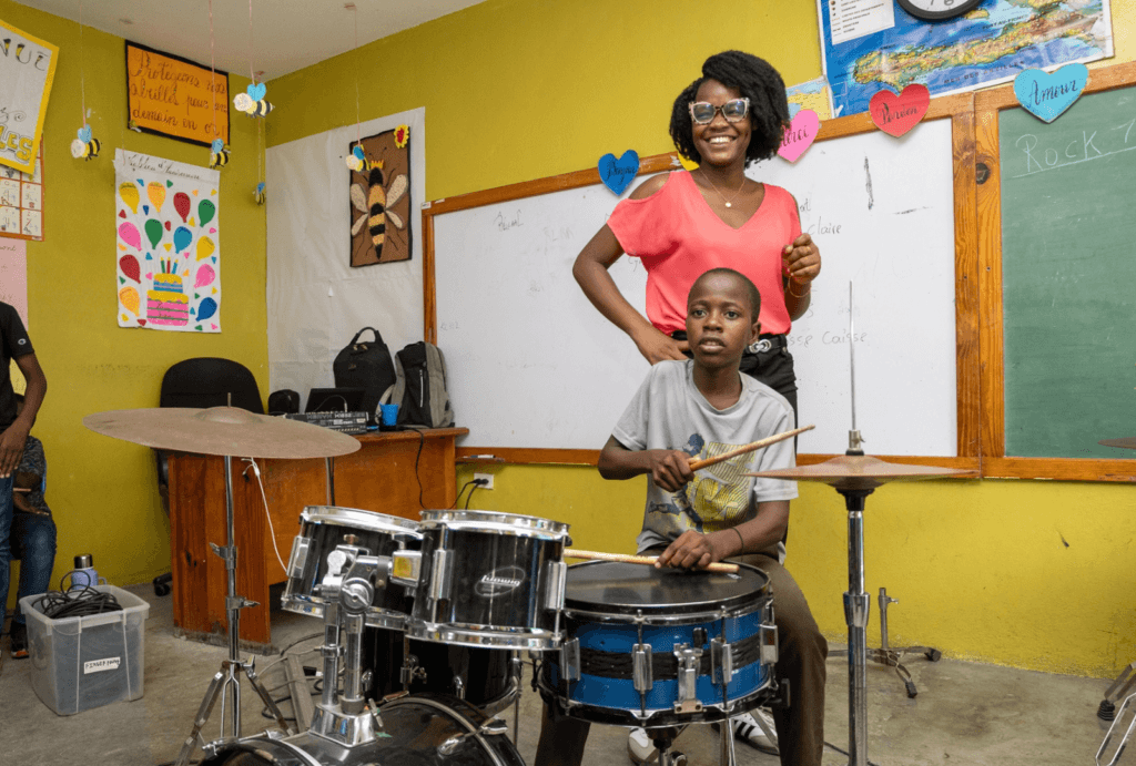 Isaac practices the drums at summer camp.